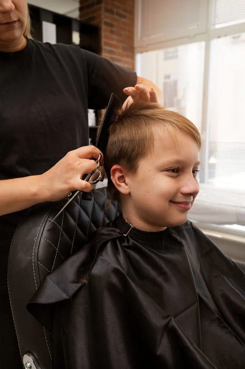 kid-getting-haircut-salon-side-view (1)