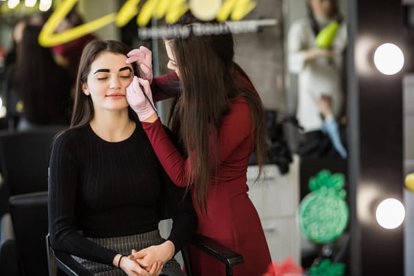 two-girls-are-doing-make-up-front-big-professional-mirror